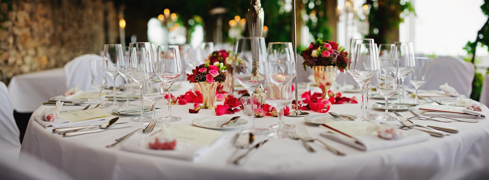 Festlich gedeckter Hochzeitstisch mit roten Rosen, Gläsern und Kerzen