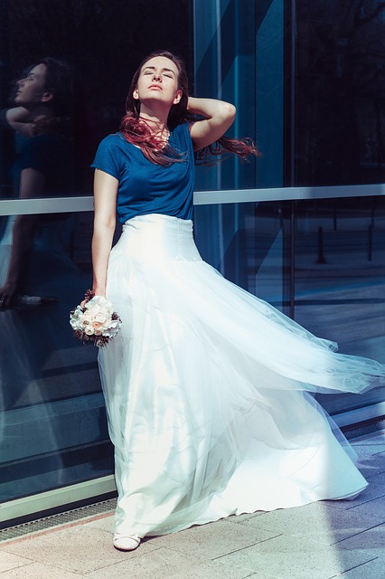 Braut in einem weißen Kleid mit kleinem Blumenstrauß