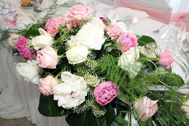 Rosafarbene und weiße Rosen als üppige Tischdekoration